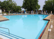 Thumbnail 23 of 31 - a large swimming pool with lounge chairs and trees in the background