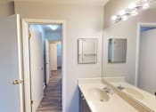Thumbnail 23 of 36 - A bathroom with a sink, mirror, and lighting fixture.