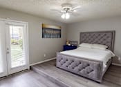 Thumbnail 7 of 30 - A bedroom with a large bed and a painting on the wall.