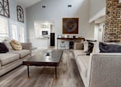 Thumbnail 12 of 30 - A living room with a brick fireplace and a wooden coffee table.