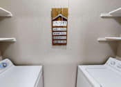 Thumbnail 11 of 30 - Laundry sign hanging on a wall above a washer and dryer.