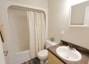 Thumbnail 8 of 11 - A bathroom with a toilet, sink, and shower.