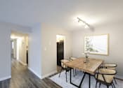 Thumbnail 2 of 11 - A dining room with a wooden table and chairs.