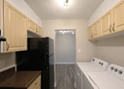 Thumbnail 5 of 11 - A kitchen with black and white appliances and wooden cabinets.
