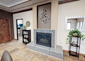 Thumbnail 16 of 19 - A living room with a fireplace and a chair.