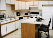 Thumbnail 3 of 19 - A kitchen with white cabinets and a white refrigerator.