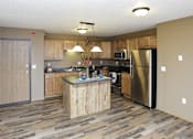 Thumbnail 4 of 19 - A kitchen with a wooden island and stainless steel appliances.