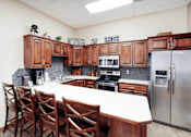 Thumbnail 1 of 19 - A kitchen with wooden cabinets and a white table.