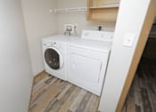 Thumbnail 10 of 19 - A white washing machine and dryer in a small laundry room.