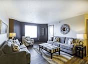Thumbnail 5 of 19 - A living room with a grey couch and a wooden coffee table.