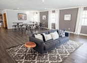 Thumbnail 13 of 32 - A living room with a grey couch and a rug.
