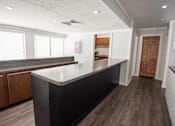 Thumbnail 25 of 32 - A kitchen with a black countertop and wooden cabinets.