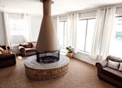 Thumbnail 21 of 32 - A living room with a large fireplace and a couch.