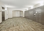 Thumbnail 10 of 24 - A hallway with a carpeted floor and a row of lockers on the right side.