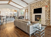 Thumbnail 15 of 24 - A modern living room with a stone fireplace and a glass coffee table.