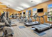 Thumbnail 11 of 24 - A gym with treadmills, elliptical machines, and other exercise equipment.