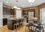 Thumbnail 1 of 24 - A kitchen with a table and chairs in the middle.