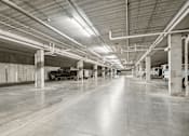 Thumbnail 16 of 24 - A black and white image of a large, empty parking garage.