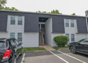 Thumbnail 10 of 12 - an apartment building with cars parked in front of it