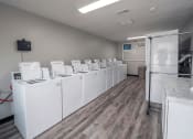 Thumbnail 7 of 12 - a row of washers and dryers in a room with wood flooring