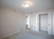 Thumbnail 9 of 17 - a bedroom with a carpeted floor and a closet with a white door