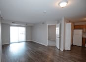 Thumbnail 4 of 17 - a living room with hardwood floors and a sliding glass door to a balcony