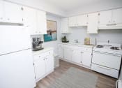 Thumbnail 4 of 18 - apartment kitchen with white cabinets and white appliances
