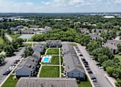 Thumbnail 29 of 30 - A bird's eye view of a residential area with houses, a swimming pool, and a parking lot.
