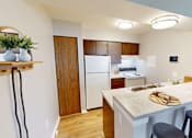 Thumbnail 3 of 30 - A kitchen with a white refrigerator and wooden cabinets.