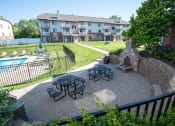 Thumbnail 11 of 31 - an outdoor patio with picnic tables and a pool in front of an apartment building