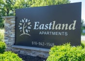 Thumbnail 31 of 31 - a stone monument sign for eastland apartments with trees in the background