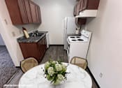 Thumbnail 4 of 21 - A kitchen with a white table and chairs and a marble counter top.