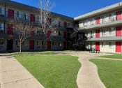 Thumbnail 23 of 28 - an apartment building with green grass and a playground