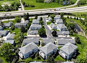 Thumbnail 32 of 34 - A suburban neighborhood with houses and a road.