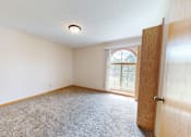 Thumbnail 11 of 34 - A room with a carpeted floor and a door leading to a window.