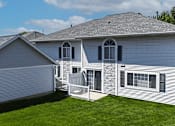 Thumbnail 26 of 34 - A house with a grey roof and white siding with a white fence in front.
