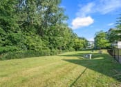 Thumbnail 22 of 23 - a yard with a fence and grass and trees for dogs