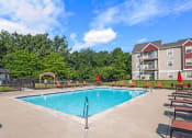 Thumbnail 20 of 23 - a swimming pool in front of an apartment building