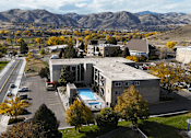 Thumbnail 27 of 30 - A large building with a pool in the middle of a parking lot.