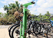 Thumbnail 15 of 30 - A green bike rack with bikes parked on it.