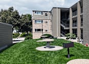 Thumbnail 24 of 30 - A modern building with a green lawn in front.
