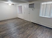 Thumbnail 9 of 30 - A room with wooden flooring and a window with blinds.
