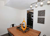 Thumbnail 3 of 23 - A dining table with a yellow object on it and chairs around it.