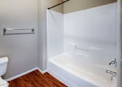 Thumbnail 14 of 25 - A white bathtub with a shower curtain rod above it.
