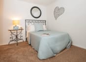Thumbnail 10 of 20 - a bedroom with a bed and a nightstand with a lamp