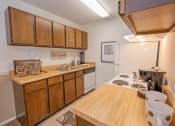Thumbnail 5 of 20 - a kitchen with wooden cabinets and a white stove top oven