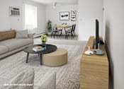 Thumbnail 2 of 8 - A living room with a grey sofa, a black coffee table, a round ottoman, a wooden TV stand, and a dining table with chairs.