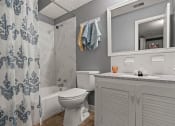 Thumbnail 11 of 23 - a bathroom with a shower and a toilet and a sink