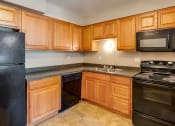 Thumbnail 4 of 23 - a kitchen with black appliances and wooden cabinets