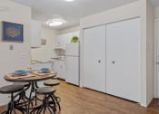 Thumbnail 9 of 25 - a kitchen with white cabinets and a small table with three stools